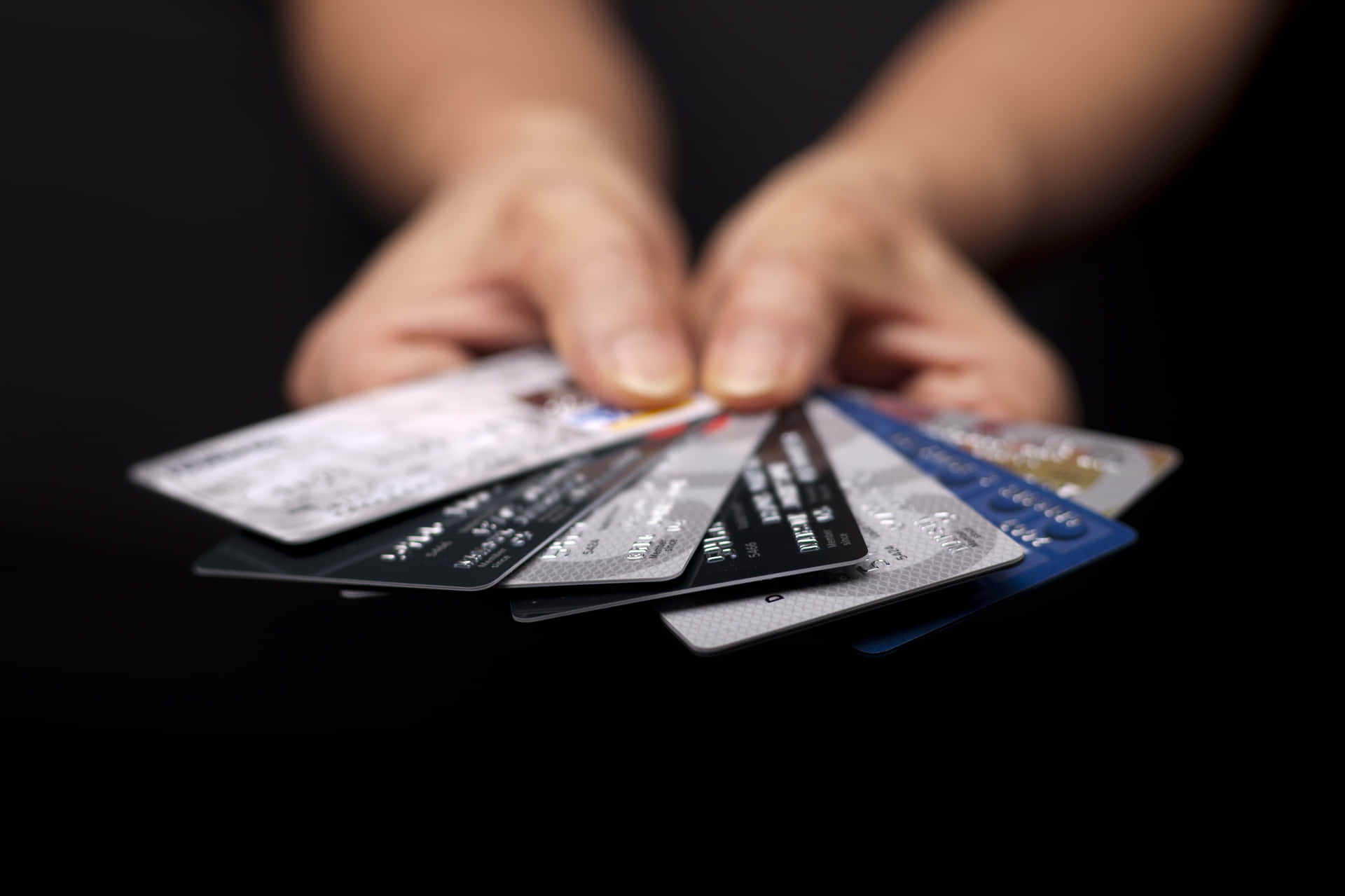 A Woman's Hands Holding Several Credit Cards