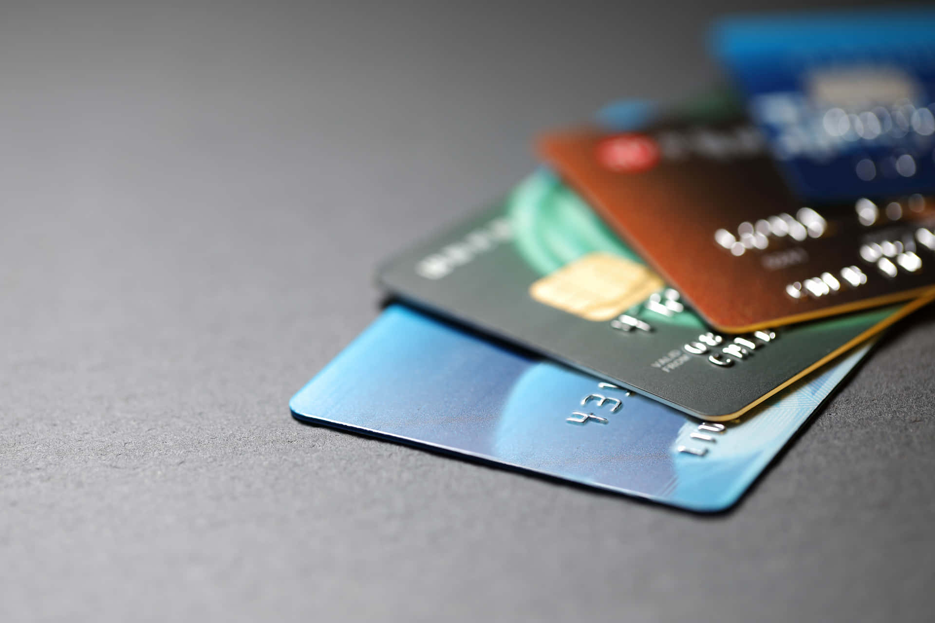 A Group Of Credit Cards On A Gray Surface