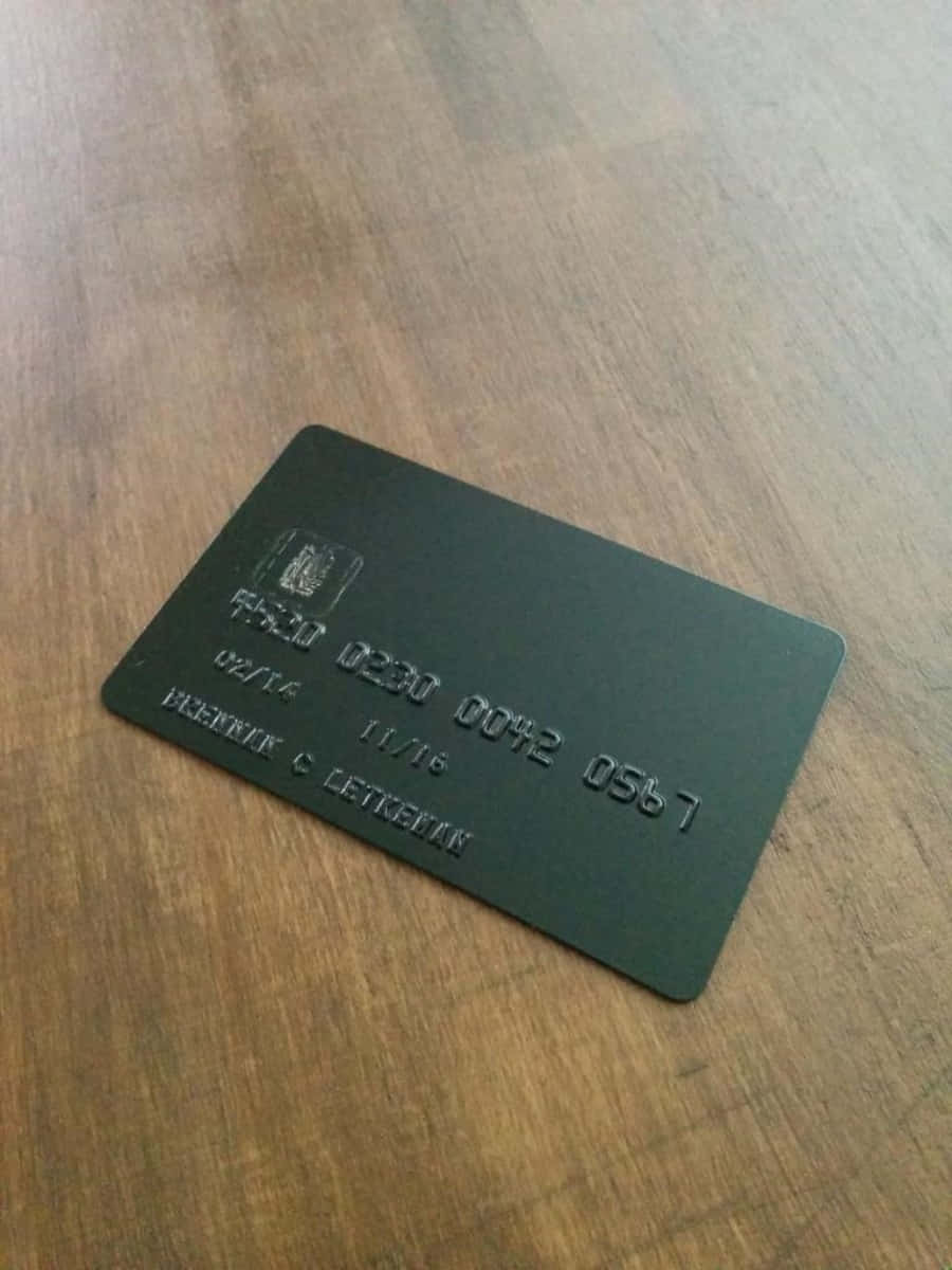 A Black Credit Card On A Wooden Table