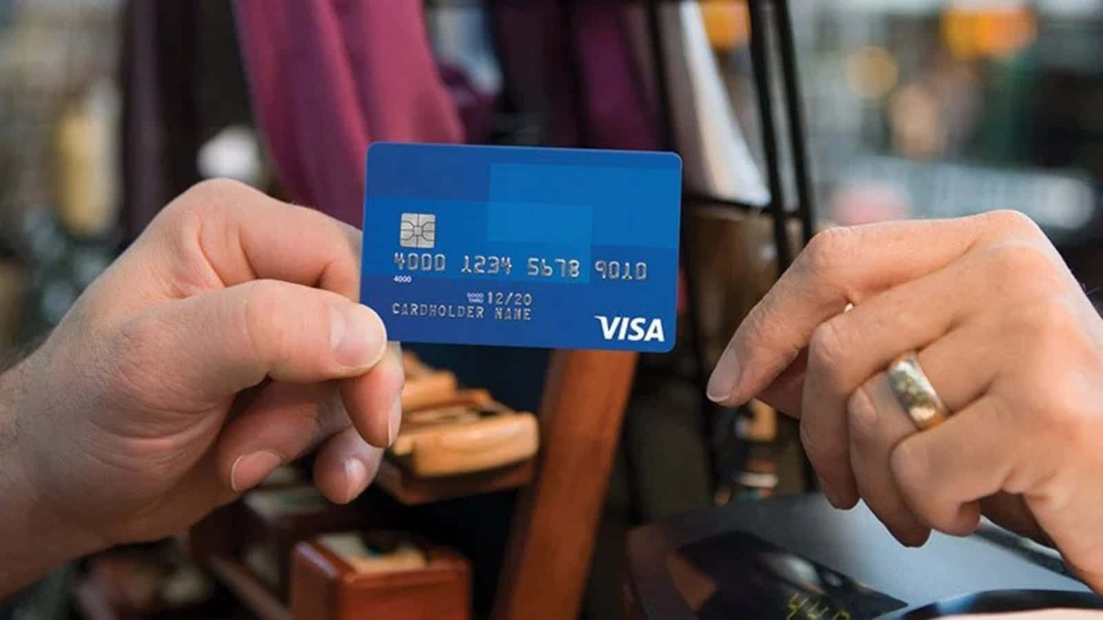 Enperson Som Håller I Ett Visa-kreditkort