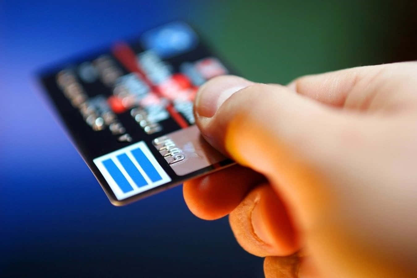 A Person Holding A Credit Card With A Blue Background