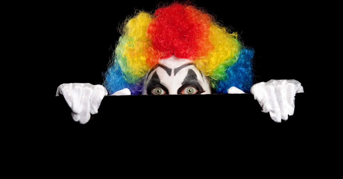 clown with rainbow hair peeking out of a black background