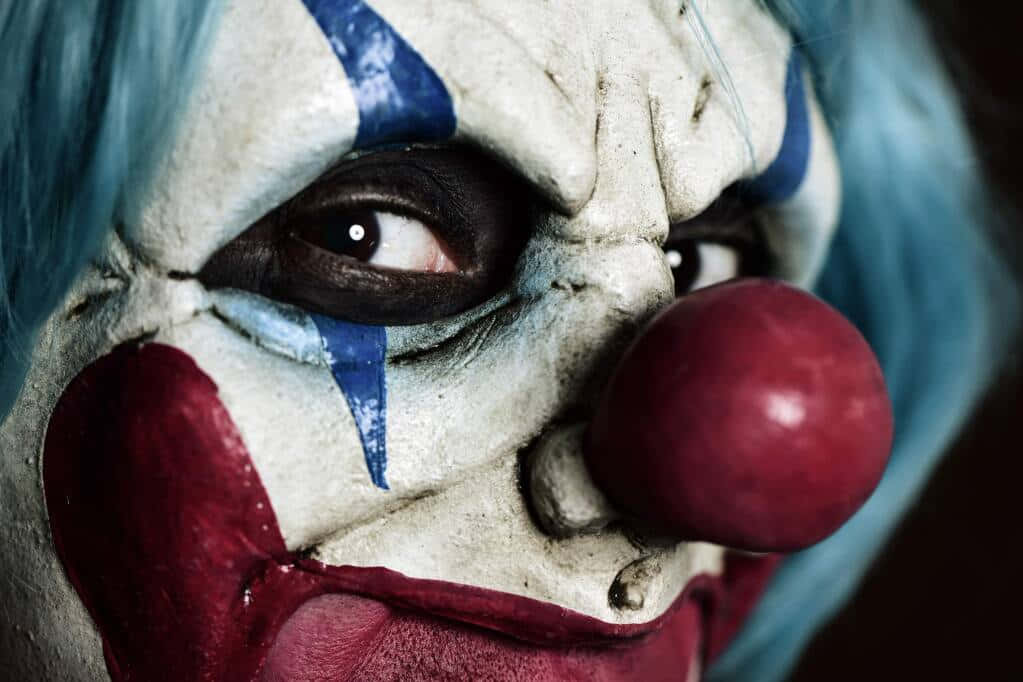 a clown with blue hair and red nose