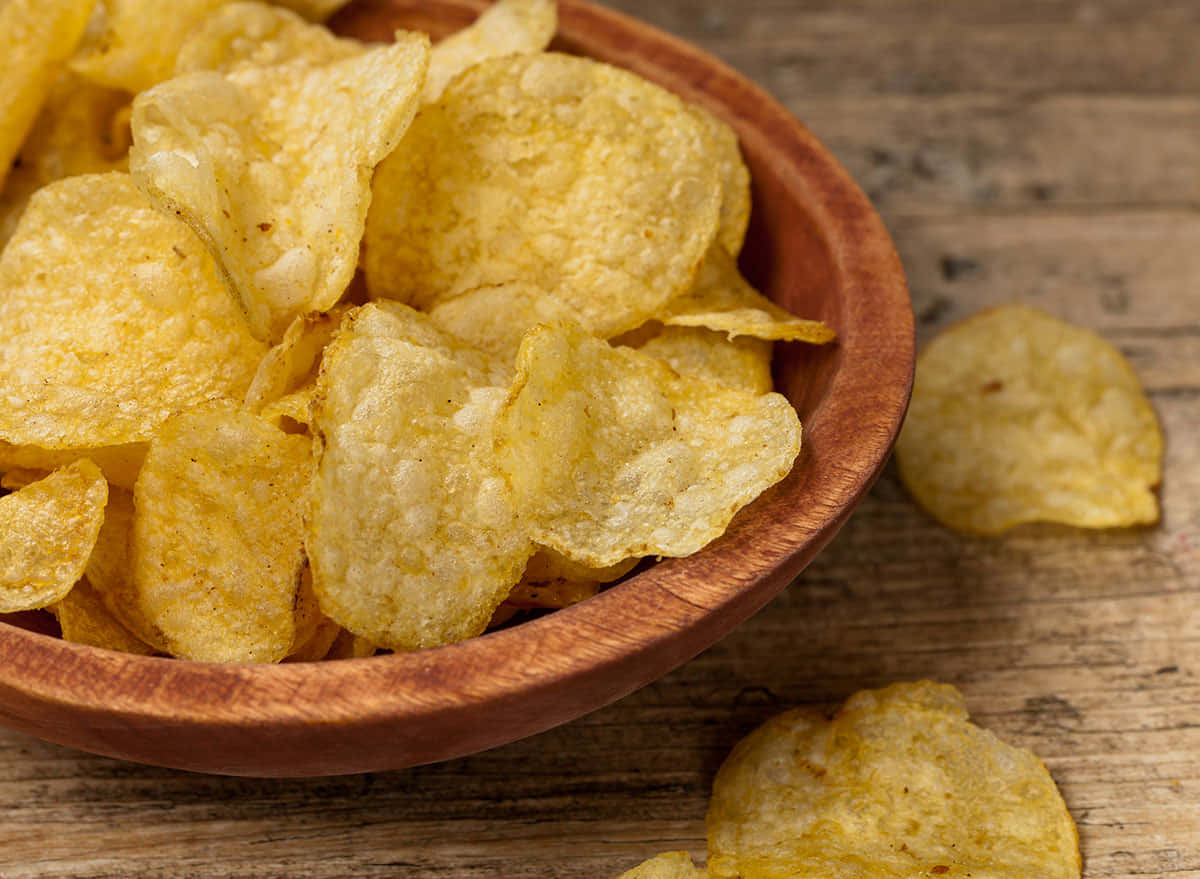 Tantalizing Crispy Potato Chips in a Ceramic Bowl Wallpaper