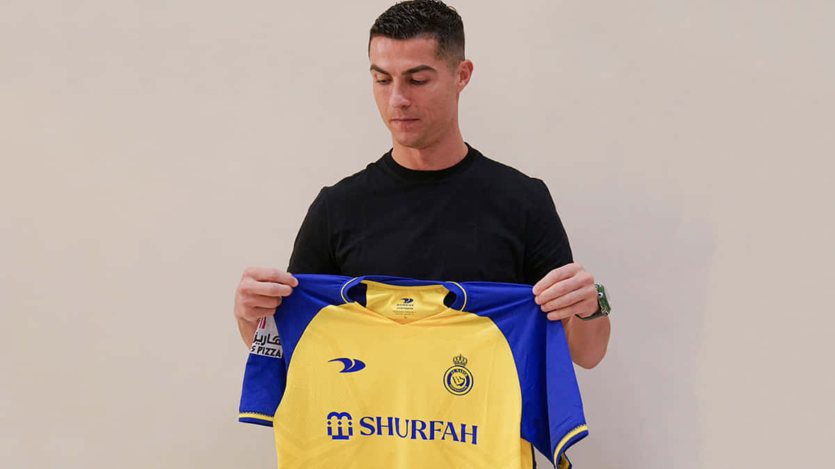 Cristiano Ronaldo Holding Yellow Jersey Wallpaper