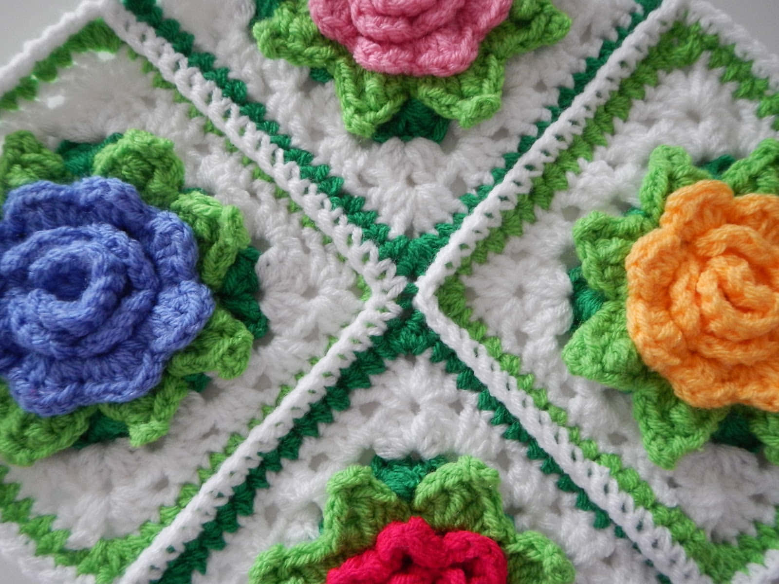 A meticulously crafted crochet blanket laid out on a vintage wooden table.