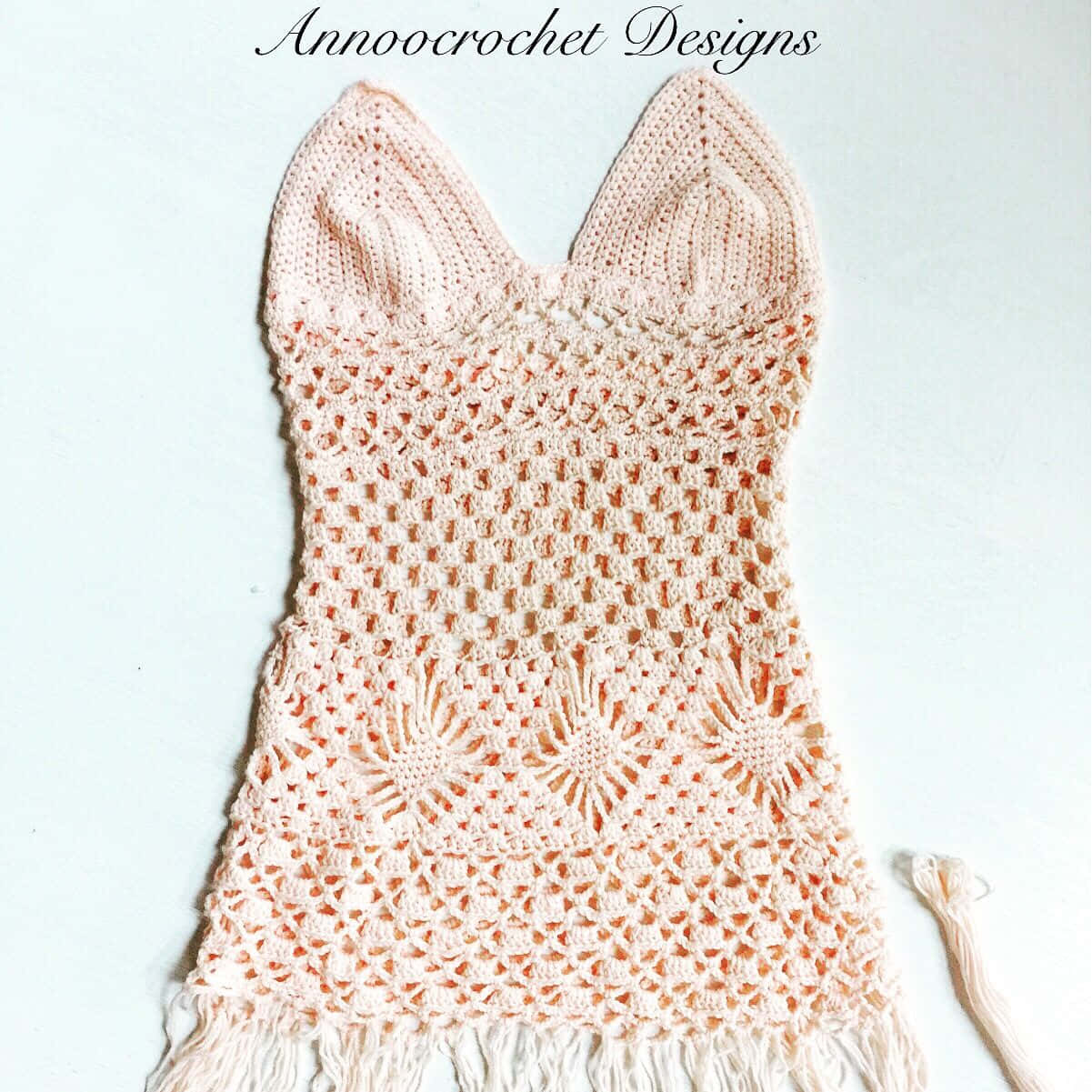 A Crocheted Dress With Fringes And A Crocheted Lace