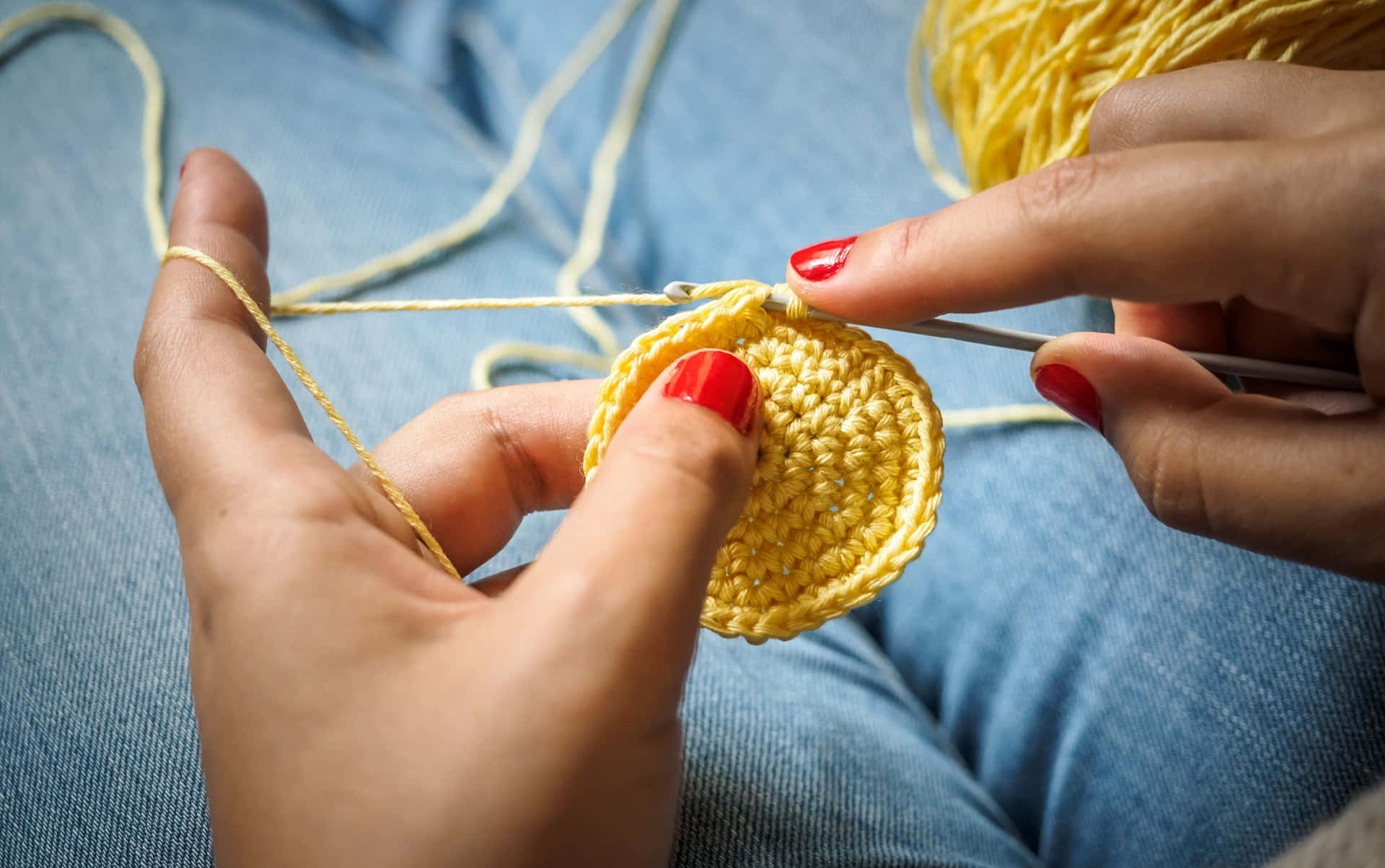 A Person Is Knitting A Yellow Crochet Ball