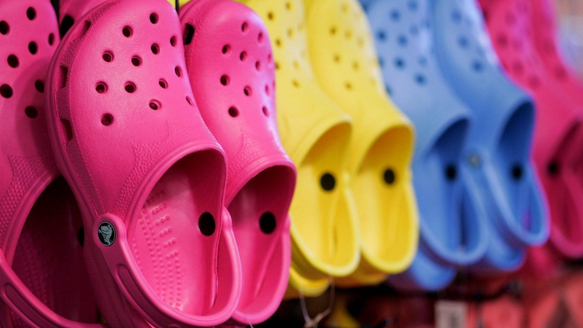 Colorful Array of Crocs Footwear on Display Wallpaper
