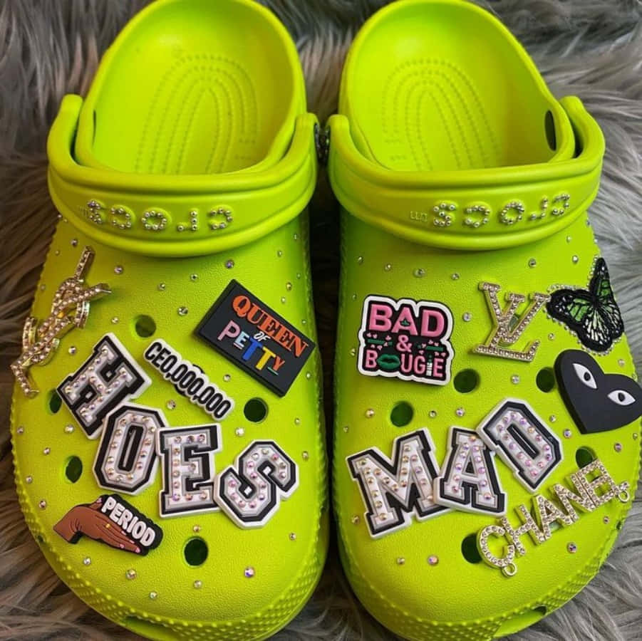 A Pair Of Green Clogs With Stickers On Them