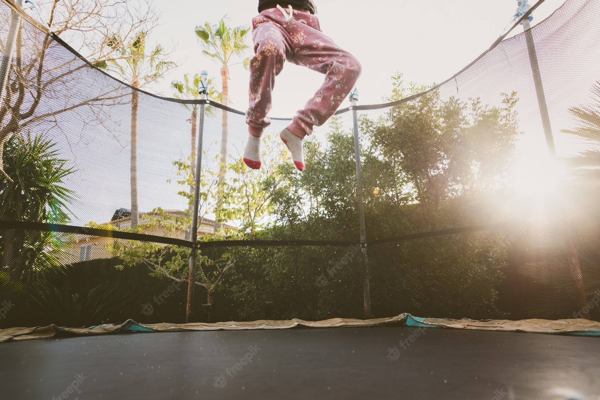 A man finds joy in mid-air while jumping on a trampoline Wallpaper