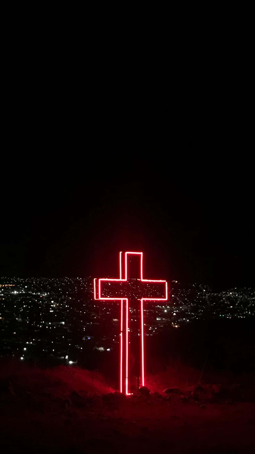 Et kors oplyst om natten i ørkenen. Wallpaper
