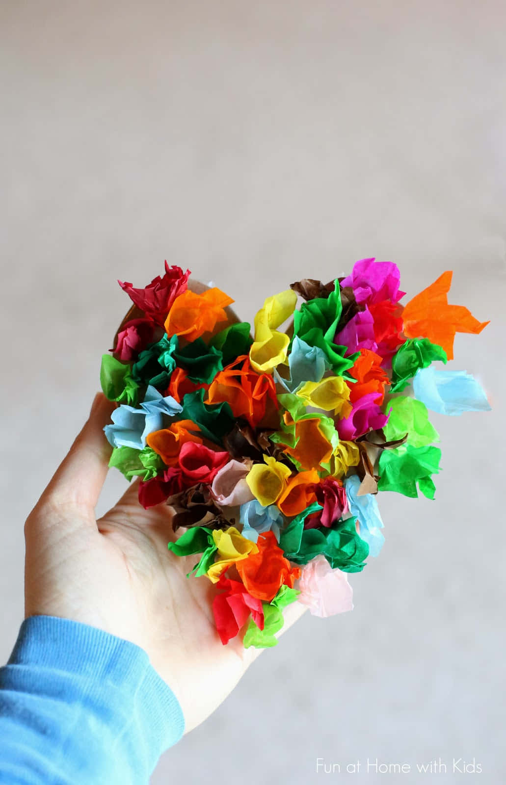 A Person Holding A Heart Made Of Colorful Tissue Paper