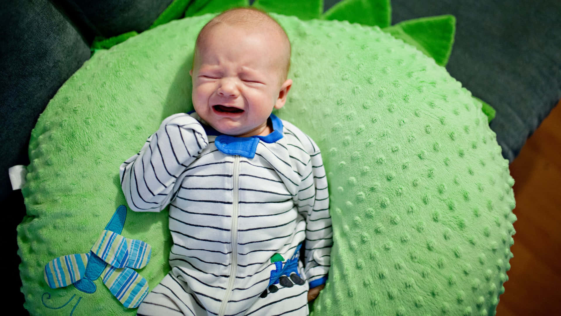 Crying Baby On Green Pillow.jpg Wallpaper