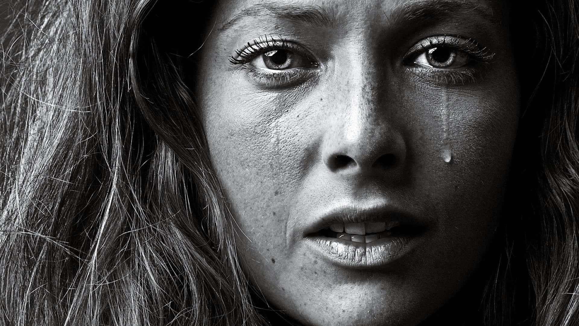 A Woman Is Crying In Front Of A Black And White Photo