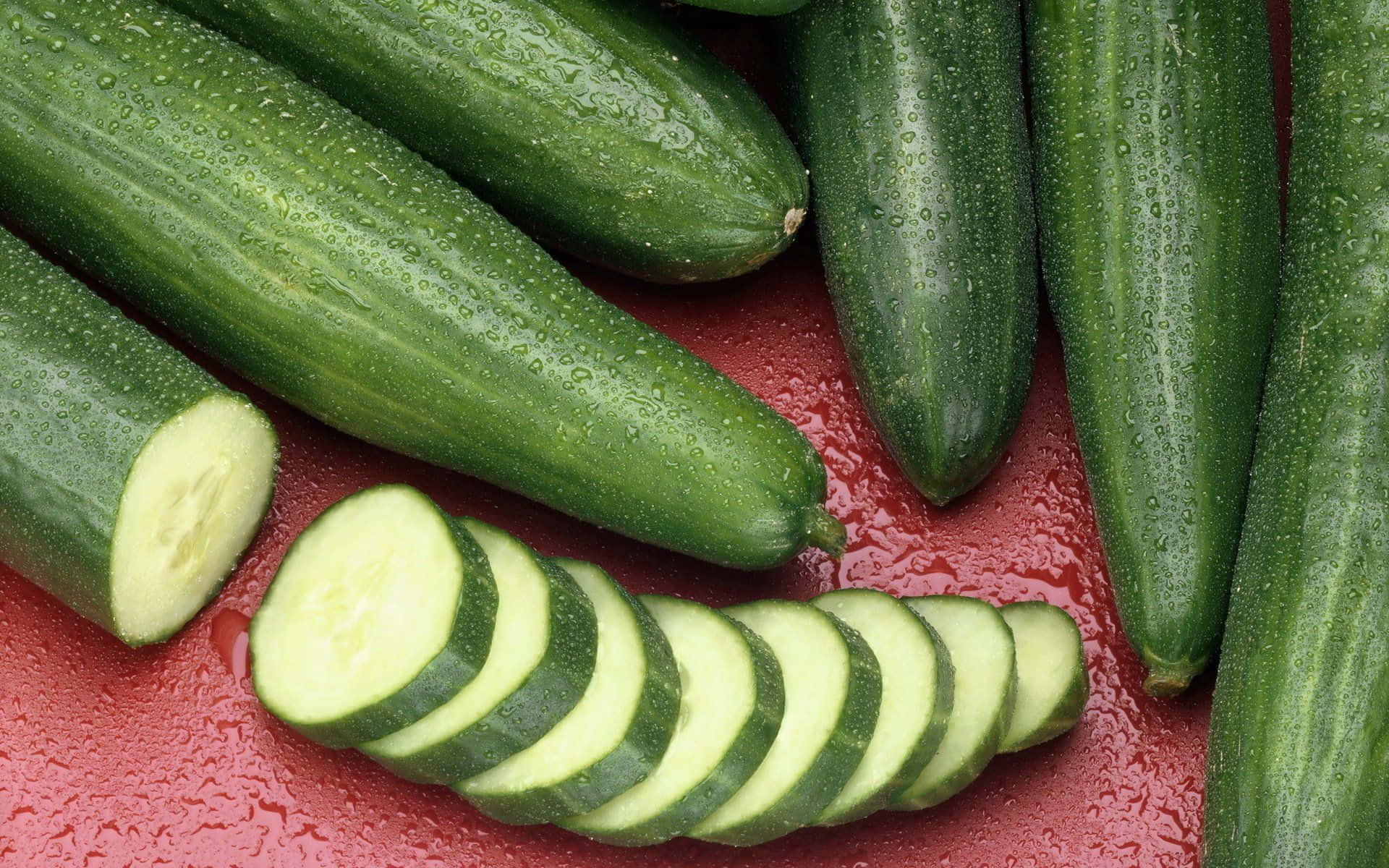Cucumbers Are Sliced And Placed On A Red Surface