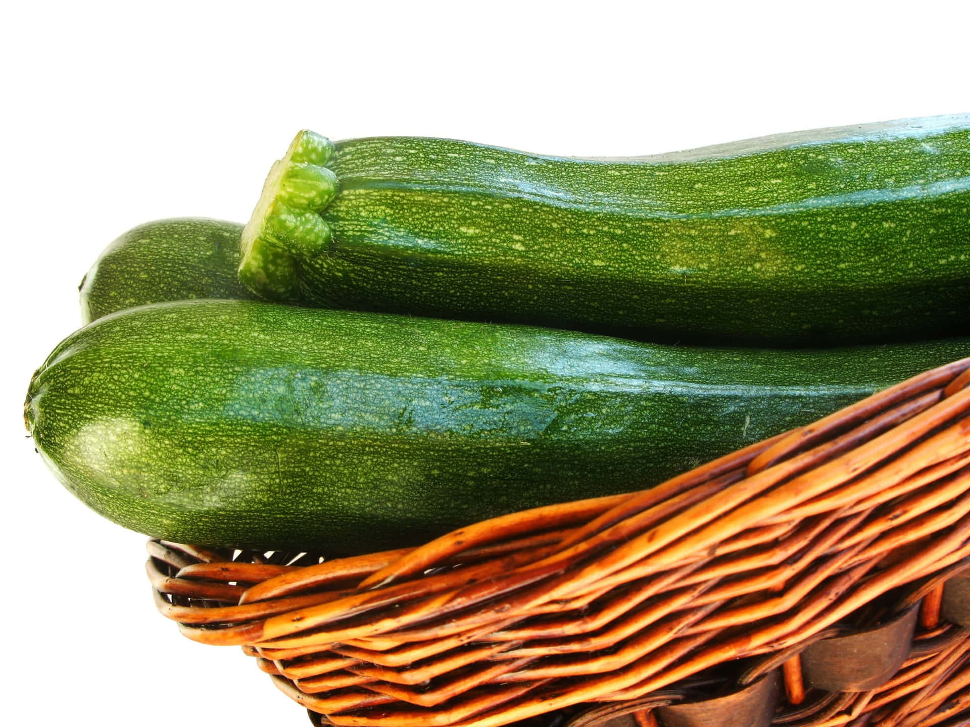 A Wicker Basket With Two Zucchinis In It