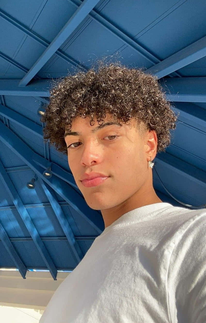 Curly Haired Boy Under Blue Pergola Wallpaper