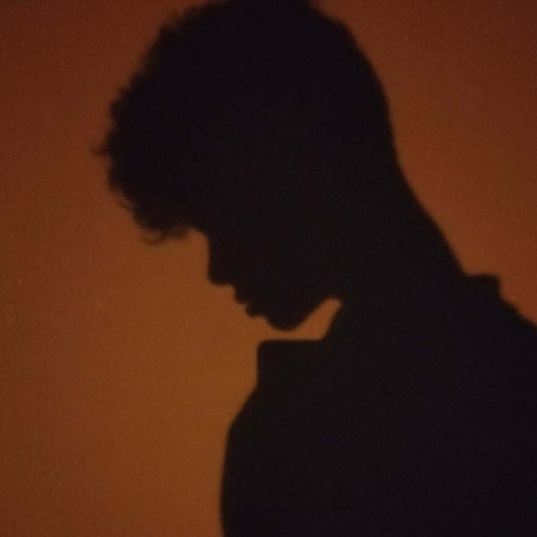 Enigmatic Curly-haired Figure in Shadow Pfp Wallpaper