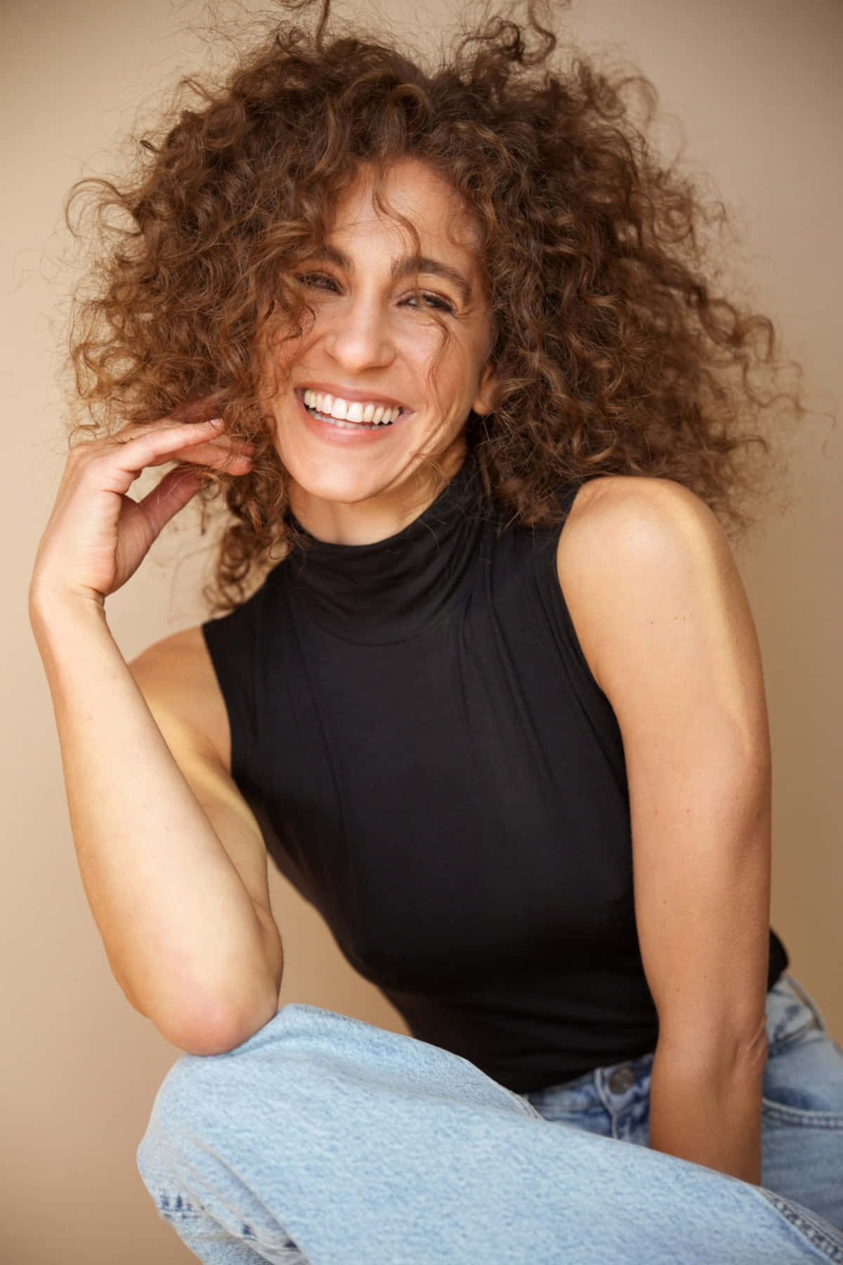 Curly Haired Woman Smiling Casually Wallpaper