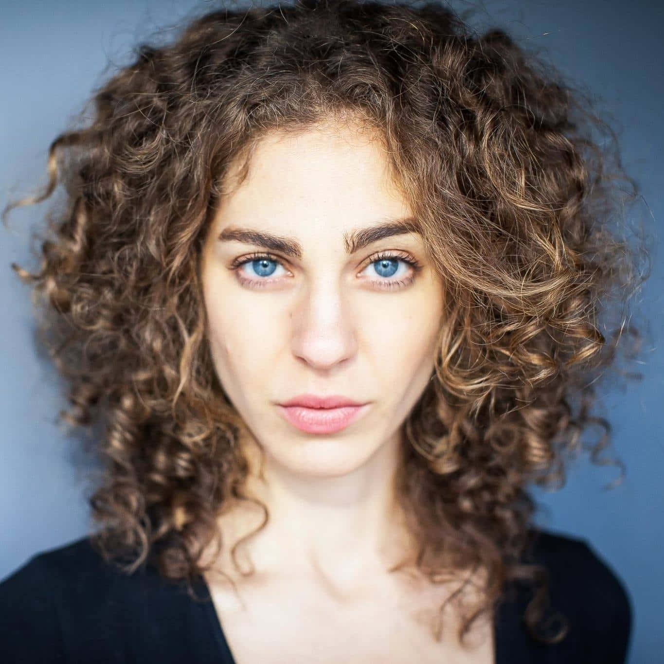 Curly Haired Woman With Blue Eyes Portrait Wallpaper
