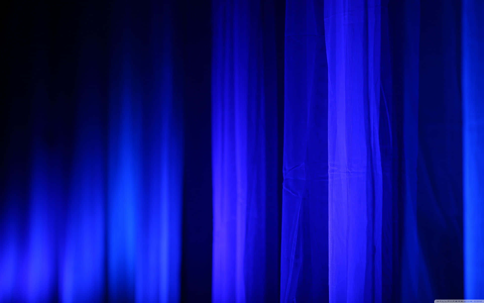 A Blue Curtain With A Light Shining Through It
