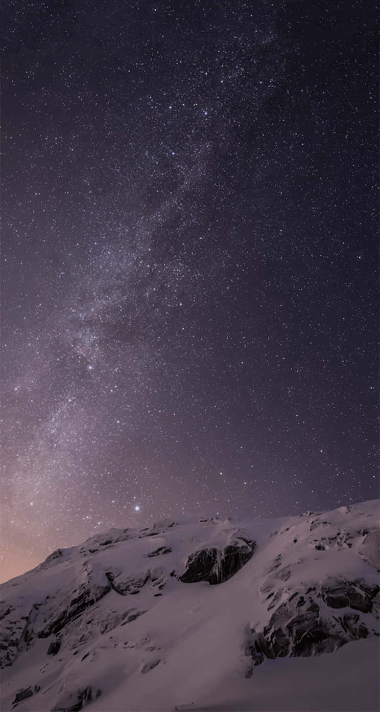 Umamontanha Coberta De Neve Com A Via Láctea Acima Dela Papel de Parede
