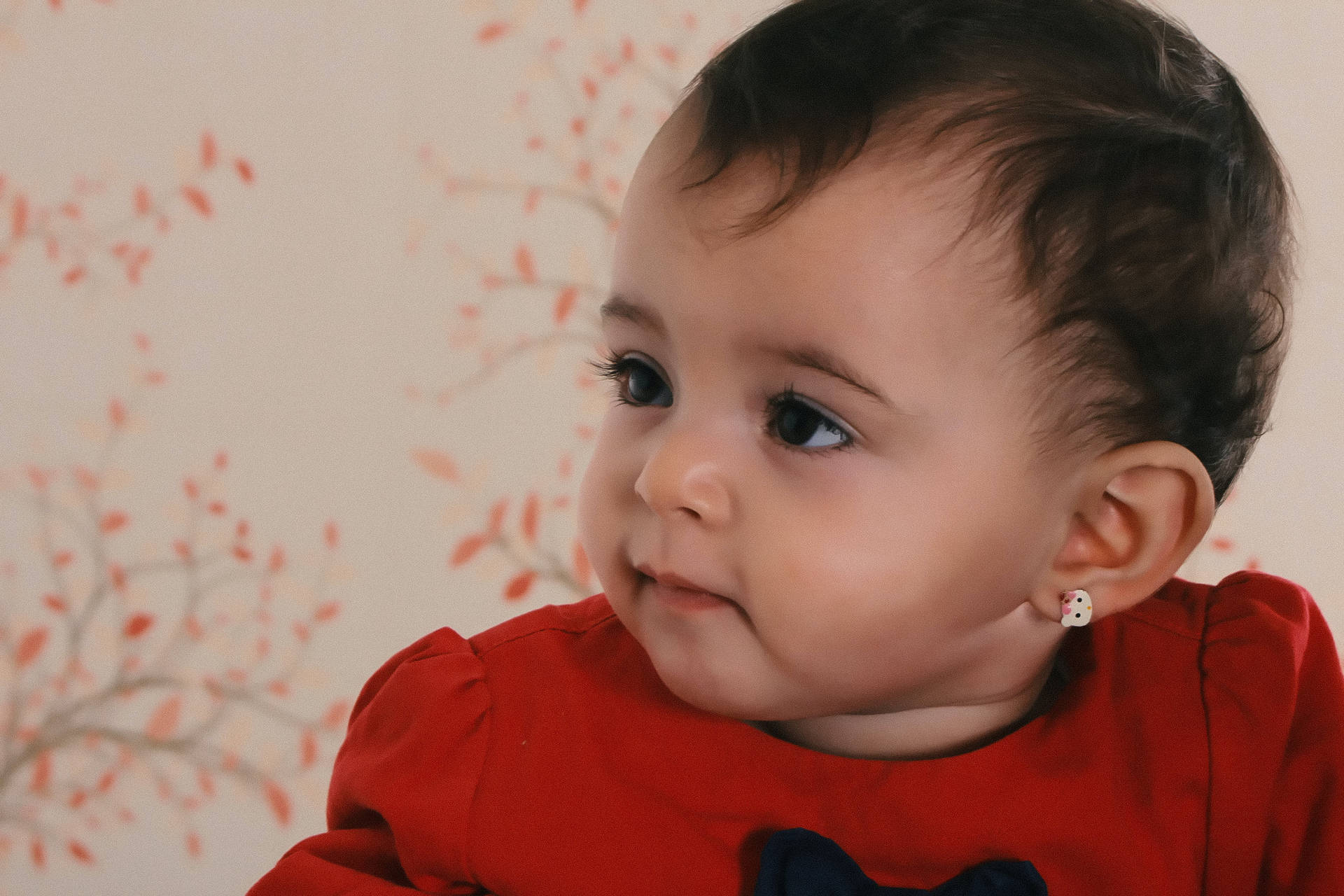 Cute Attentive Baby Girl In Red Wallpaper