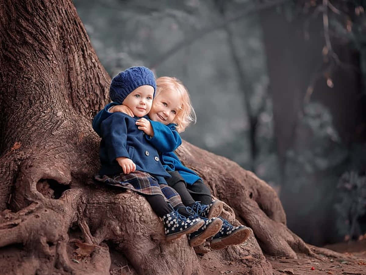Download Cute Baby Couple Hugging Under The Tree Wallpaper 