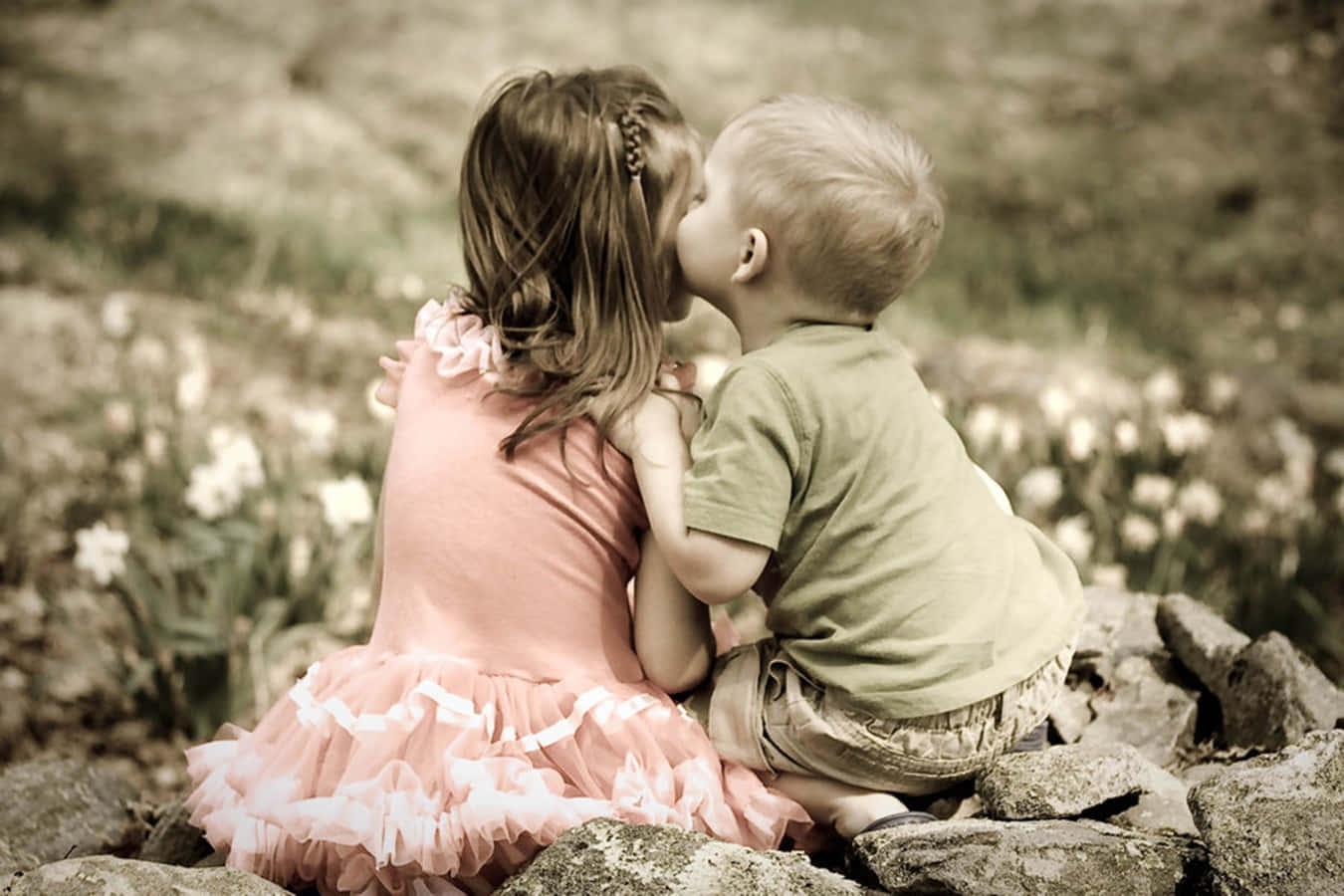 Cute Baby Couple Kissing In The Garden Wallpaper