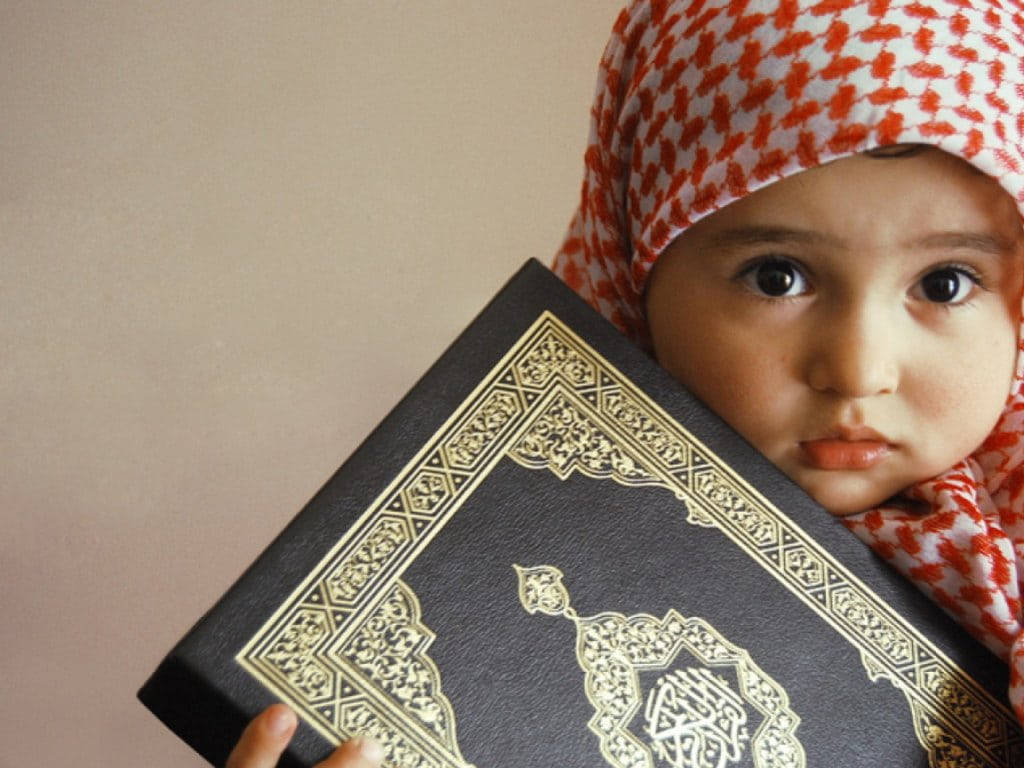 Cute Baby Islamic Boy With Quran Background