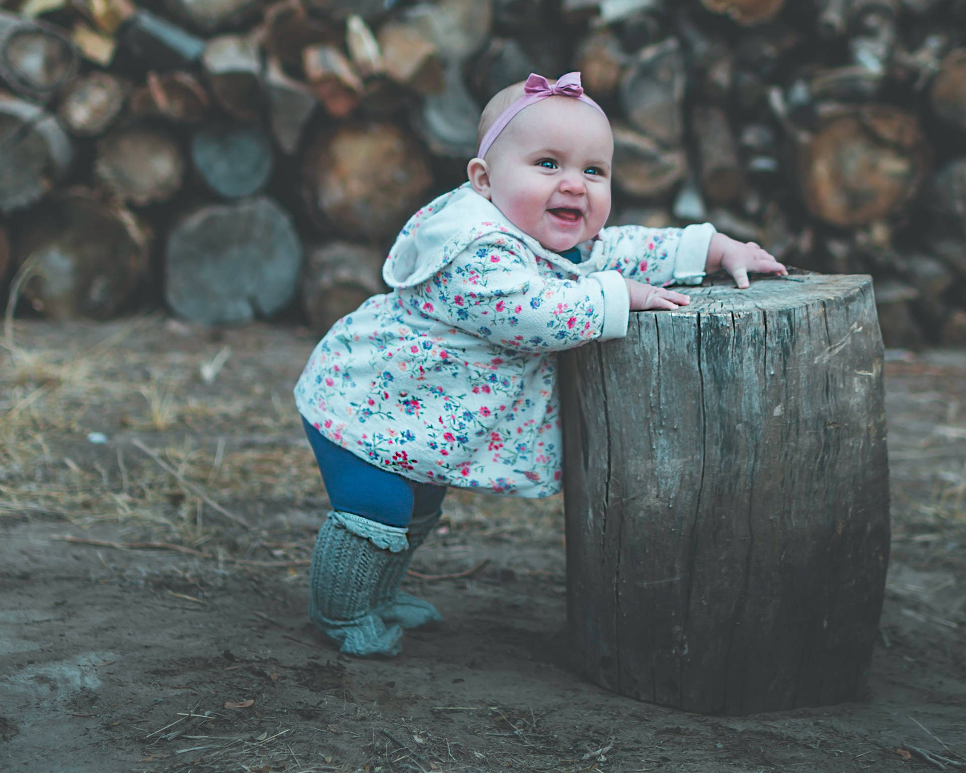 Cute Baby Leaning On Tree Stump Wallpaper