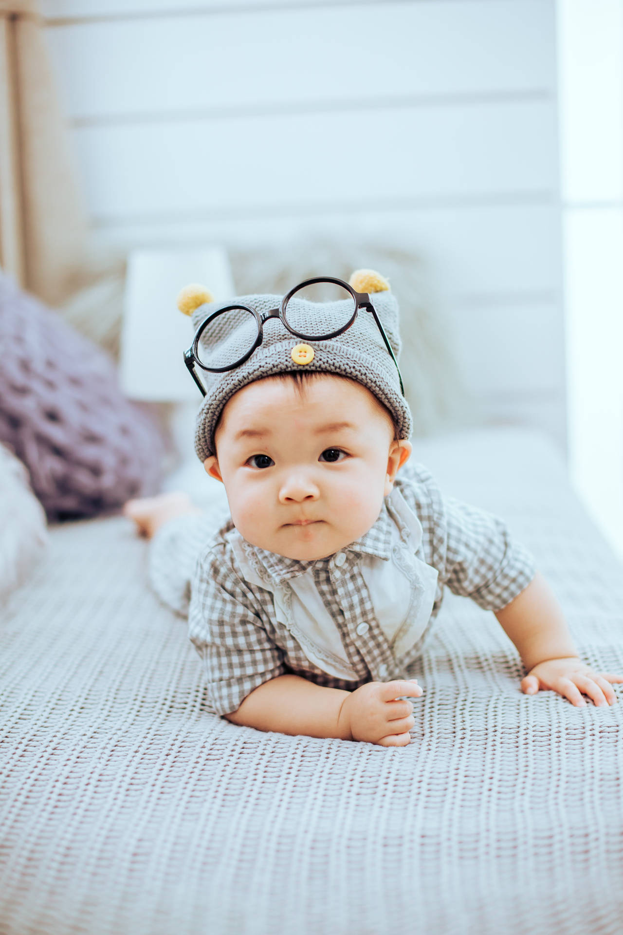 Download Cute Baby On Bed With Eyeglasses Wallpaper 