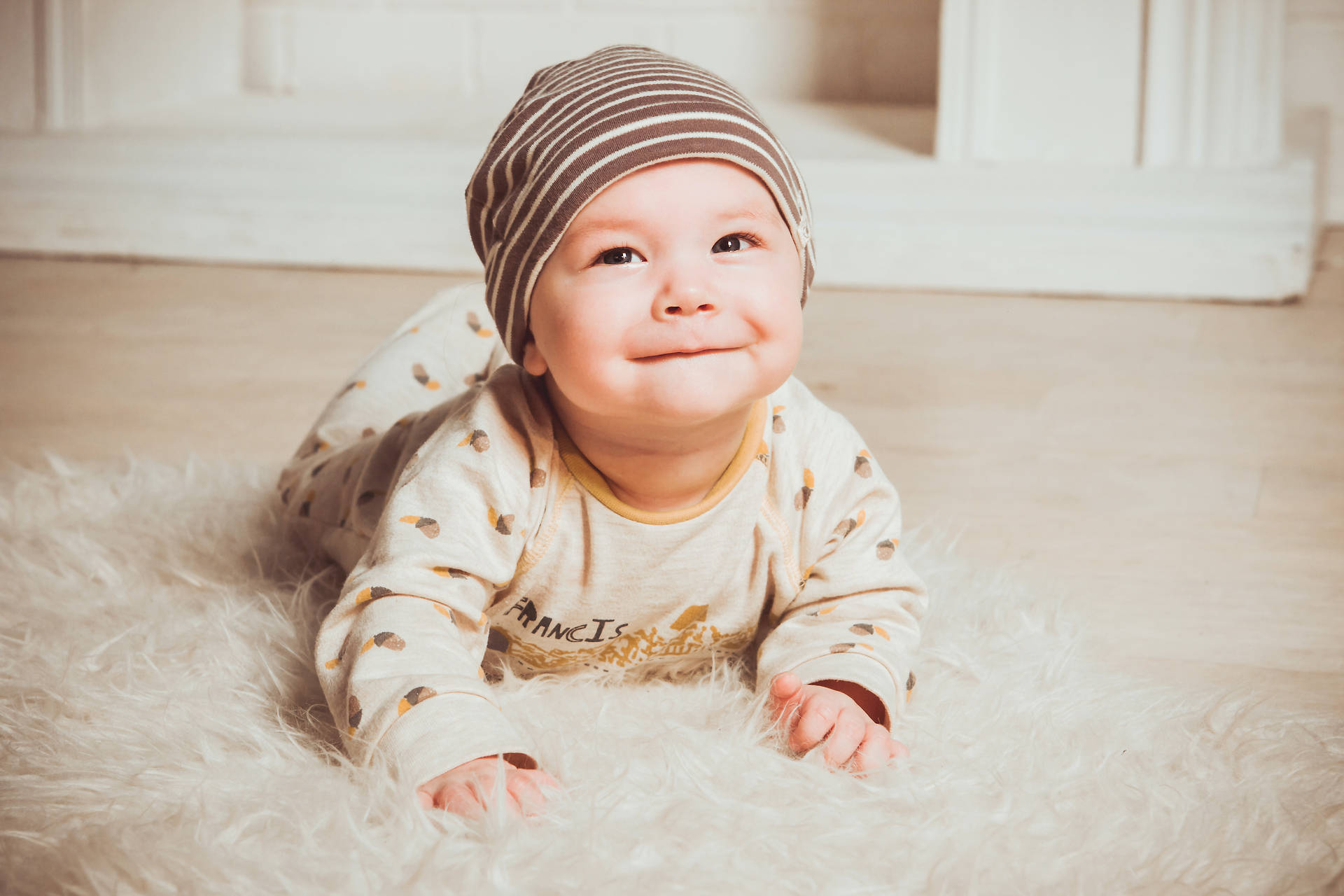 Adorable Baby with a Mischievous Smile Wallpaper