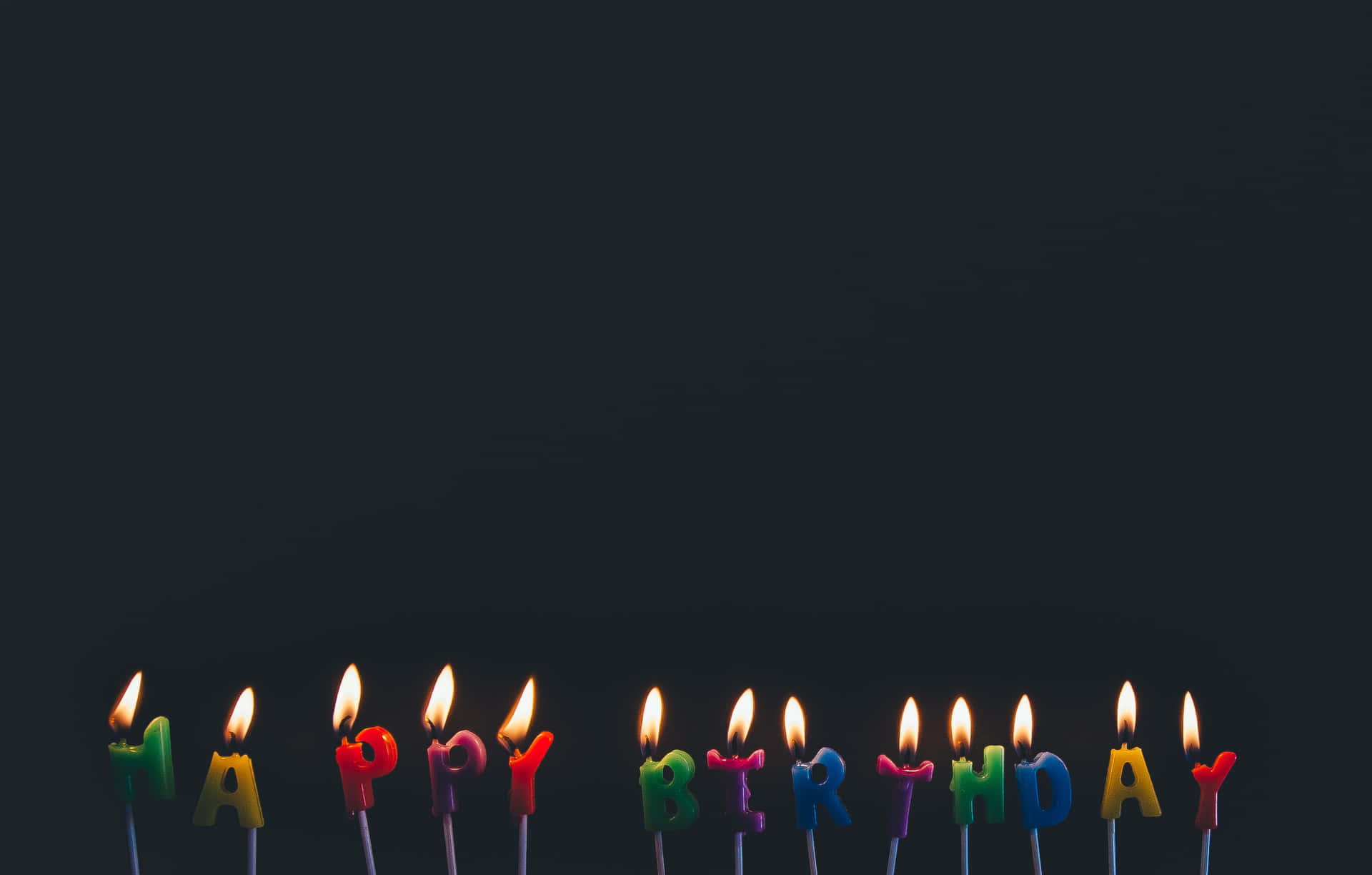 A Group Of Candles With Happy Birthday Written On Them Wallpaper