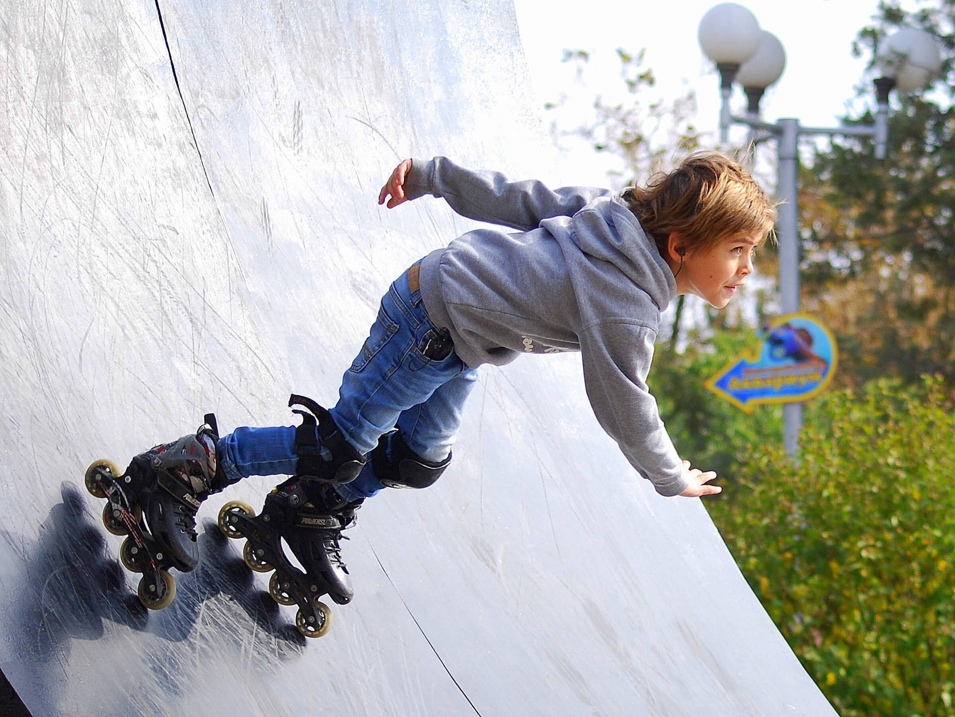 Active young boy enjoying a day rollerblading Wallpaper