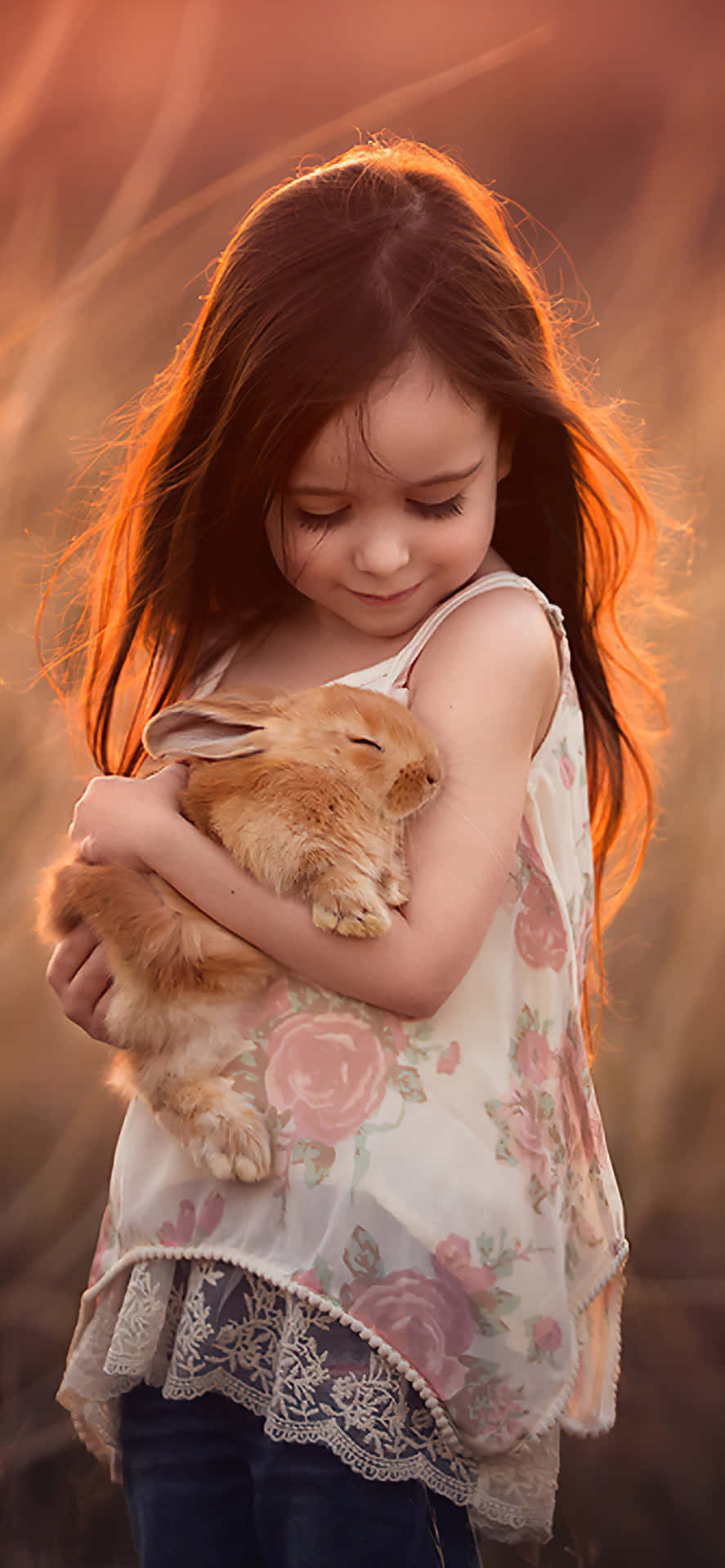 A Little Girl Holding A Rabbit In The Field Wallpaper