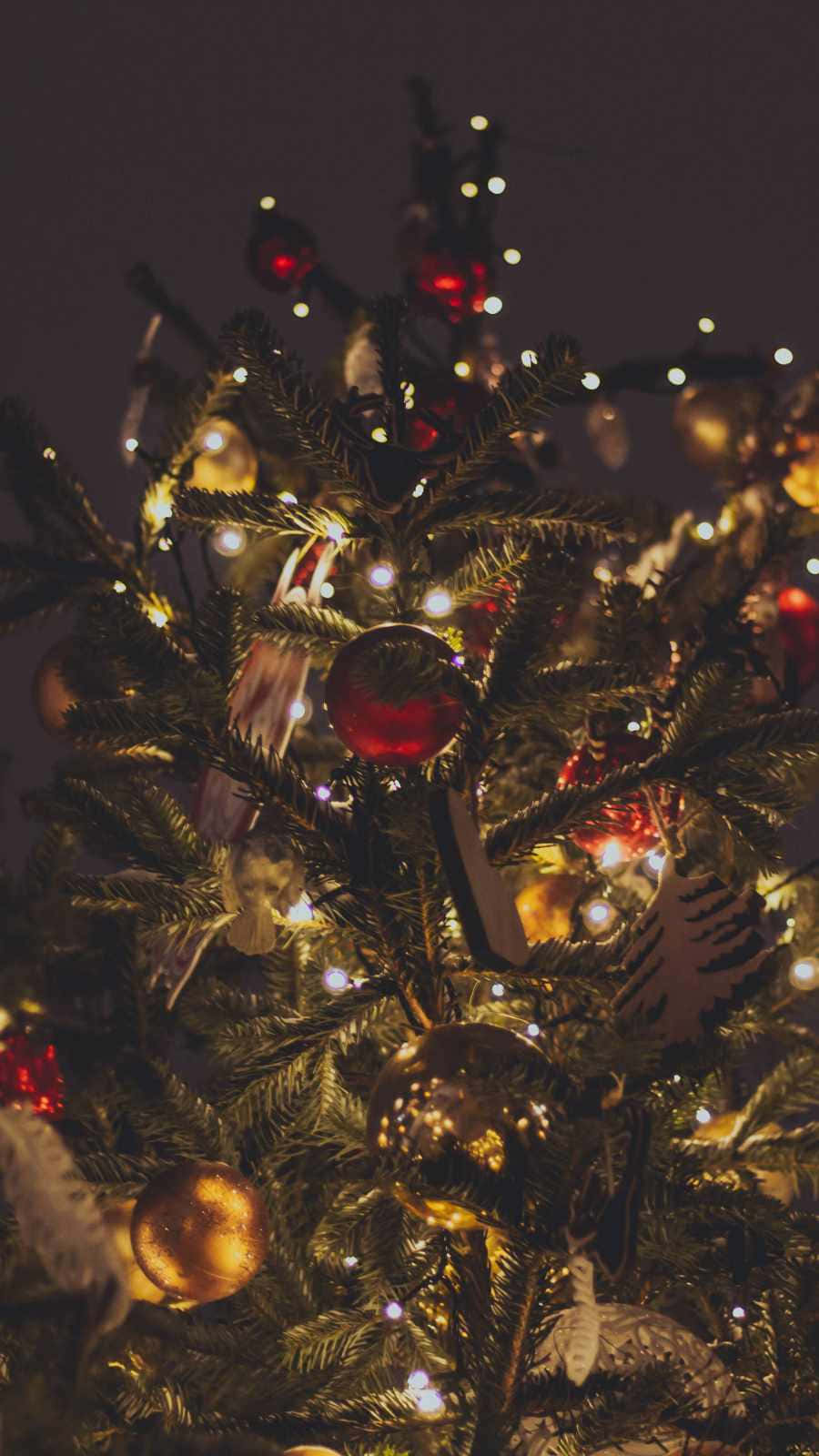 A Christmas Tree With Ornaments And Lights Wallpaper