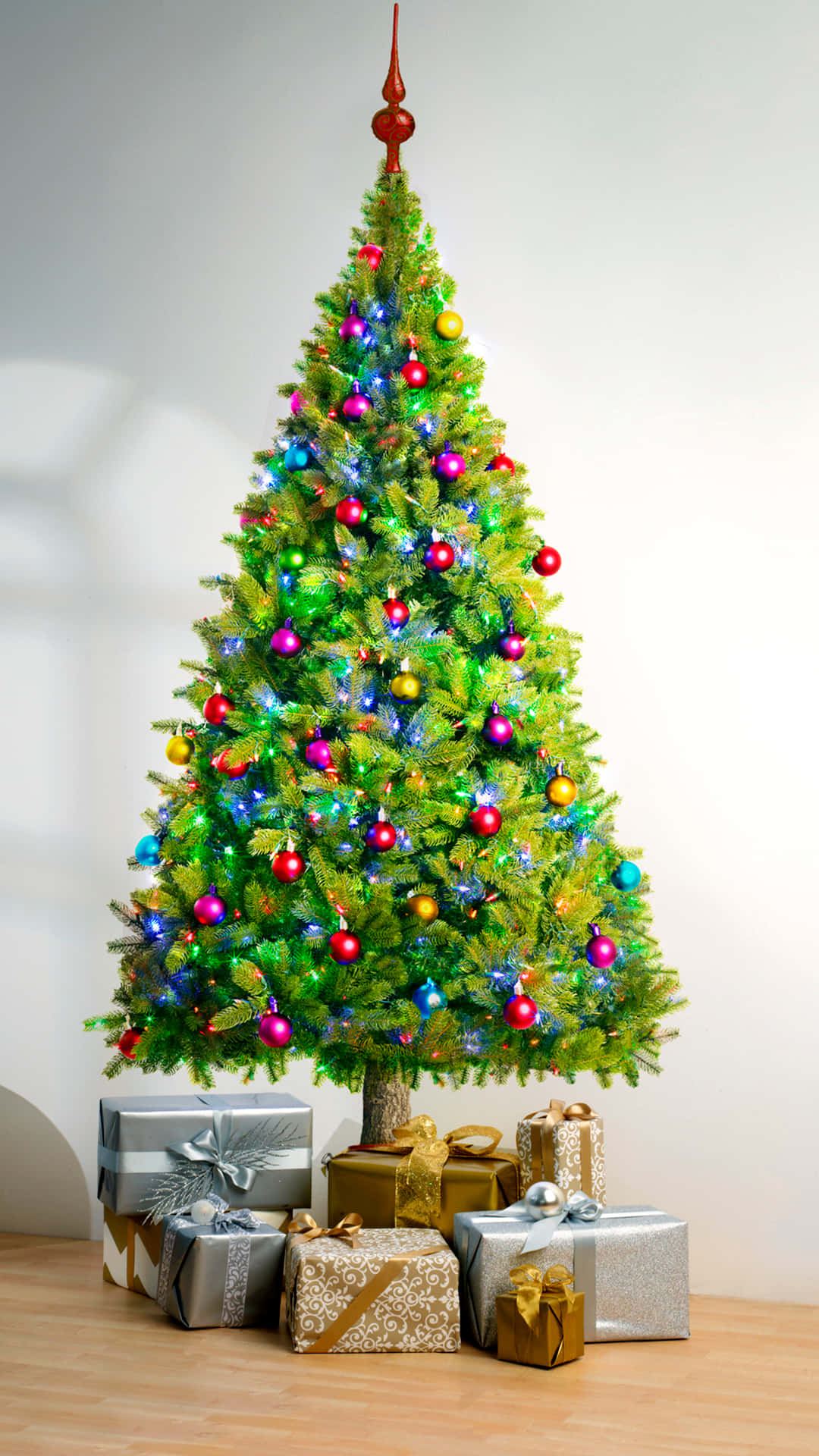 A cute Christmas tree dressed up with colorful decorations Wallpaper