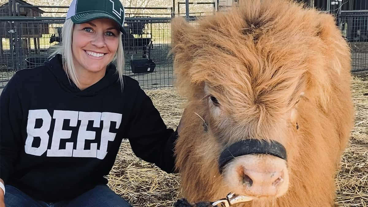 A Woman Is Posing With A Brown Cow