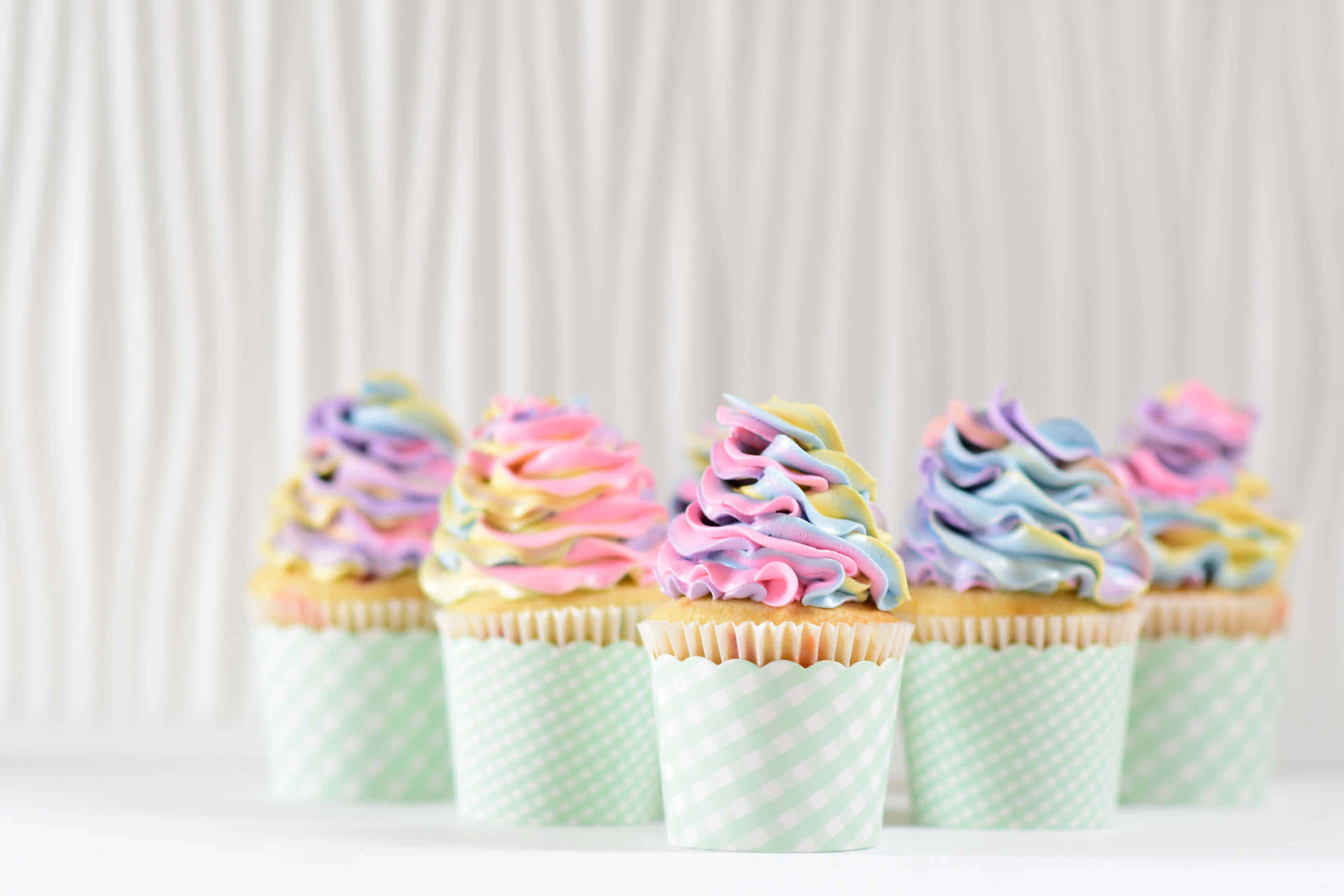 Adorable Pink Frosted Cupcake with Rainbow Sprinkles Wallpaper