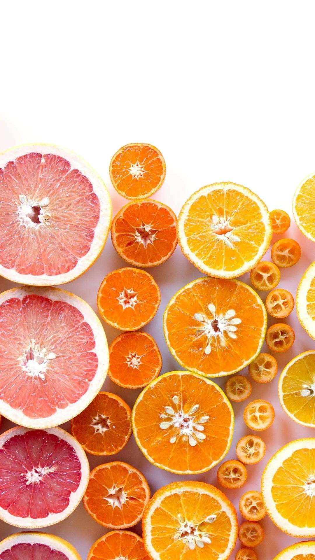 En bunke af appelsiner og grapefrugter spredt over en lyseblå tapet. Wallpaper