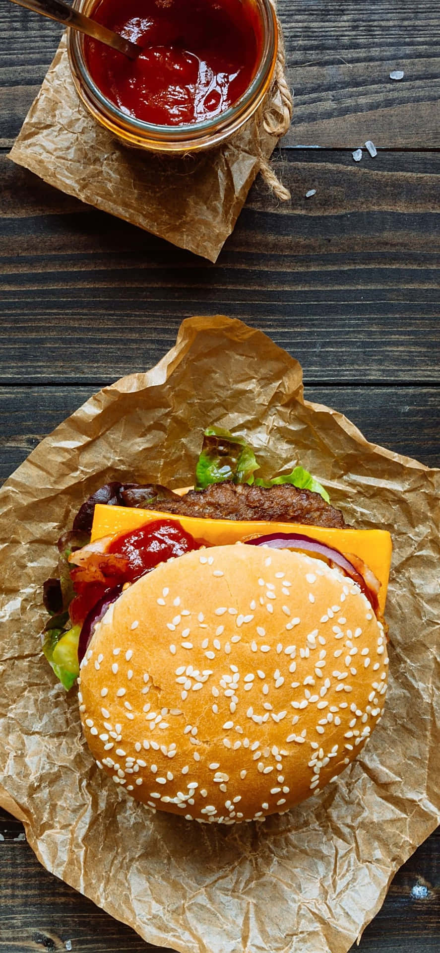 A Hamburger With Ketchup And Mustard On A Brown Paper Wallpaper
