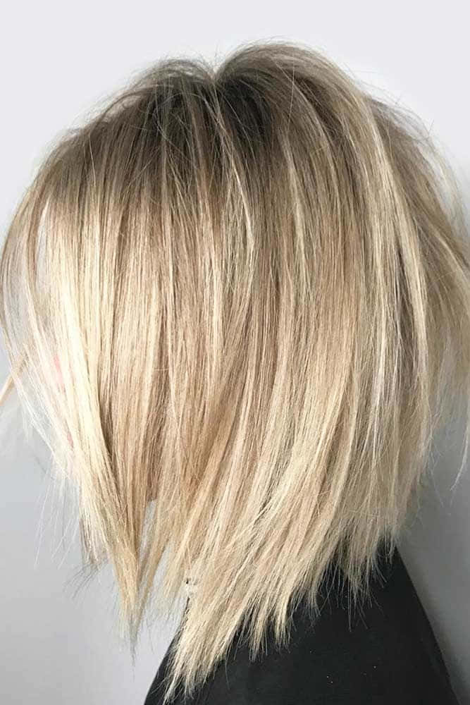 A Woman With Blonde Hair And A Layered Bob