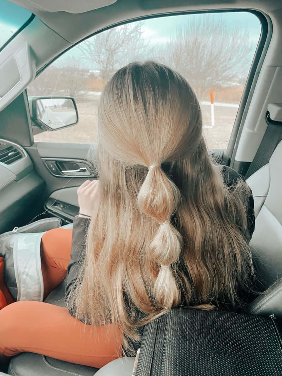 A Girl Sitting In The Back Seat Of A Car