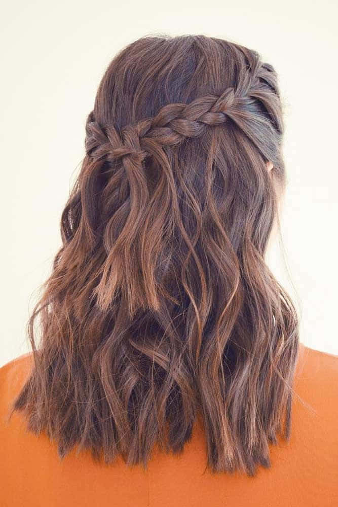 A Woman With Long Brown Hair In A Braided Updo