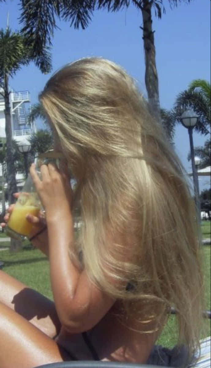 A Woman With Long Hair Drinking A Drink