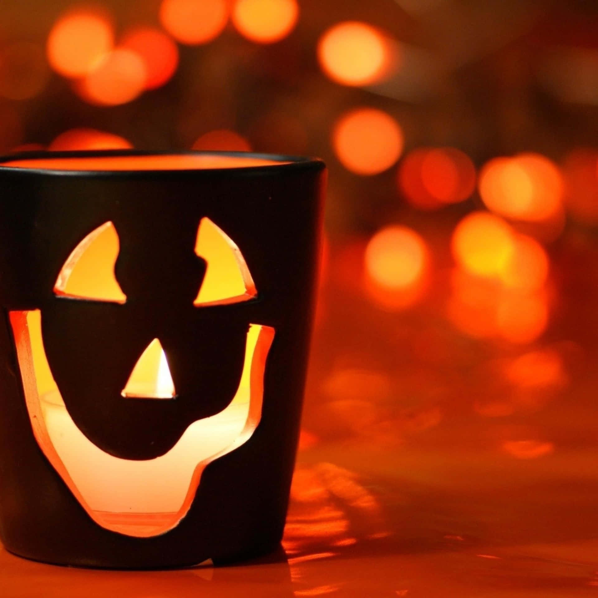A Black Candle With A Jack O Lantern Face On It