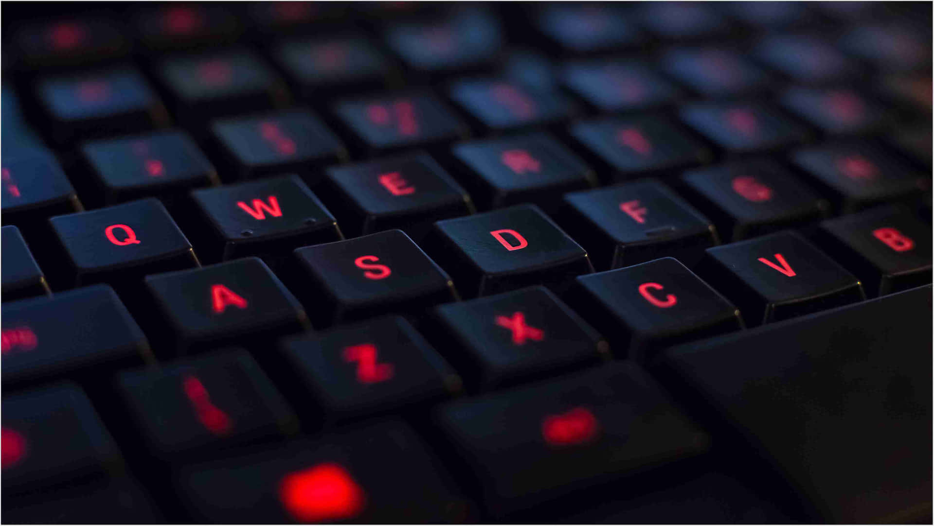 A Close Up Of A Keyboard With Red Letters