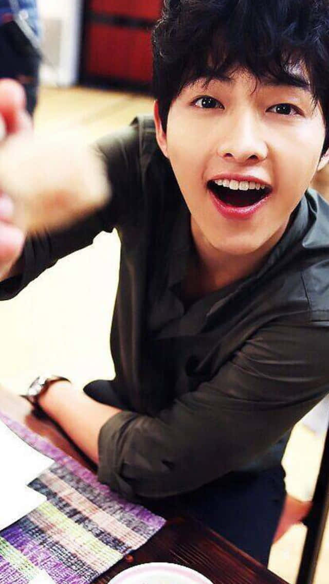 Cute Korean Actor Song Joong Ki Holding A Spoon Wallpaper